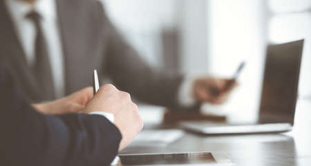 Unknown business people using laptop computer at the desk in modern office. Businessman or male...