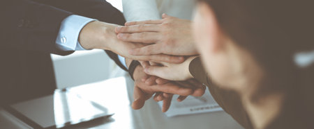 Business people group showing teamwork and joining hands or giving five in modern office. Unknown...