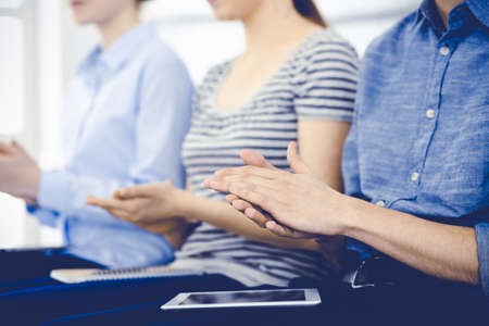 Business people clapping at meeting or conference, close-up of hands. Group of unknown businessmen...