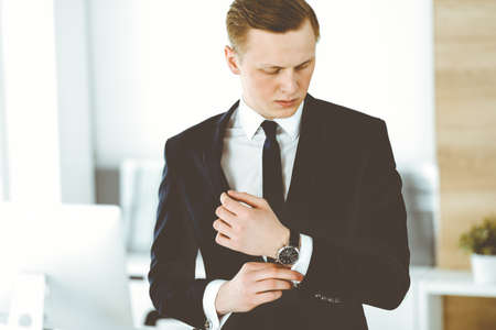 Cheerful businessman standing and looking at camera in office. Headshot of young and successful entrepreneurの写真素材
