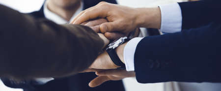 Business people group showing teamwork and joining hands or giving five in modern office. Unknown...