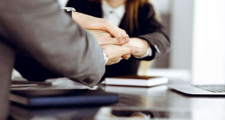 Unknown business people group joining hands in modern office. Businessmen and women making circle...
