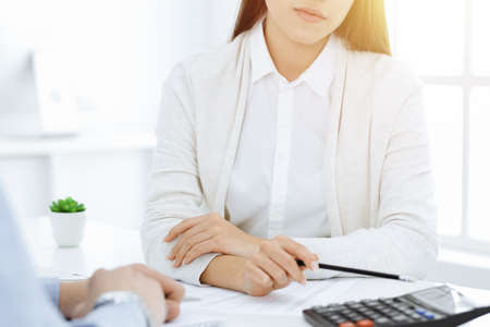 Bookkeeper checking balance with calculator, close-up of hands. Tax and audit conceptsの写真素材