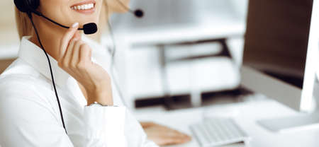 Unknown female customer service representative is consulting clients online using headset.close-up....