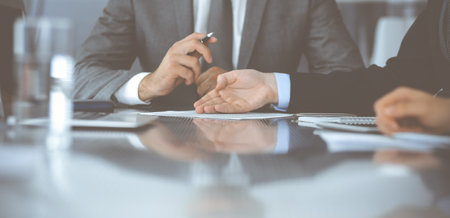 Unknown business people working together at meeting in modern office, close-up. Businessman and...