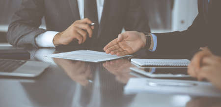 Unknown business people working together at meeting in modern office, close-up. Businessman and woman with colleagues or lawyers discussing contract at negotiationの写真素材
