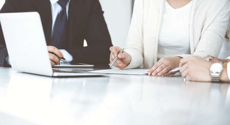 Business people discussing contract working together at meeting in modern office. Unknown businessman and woman with colleagues or lawyers at negotiationの写真素材