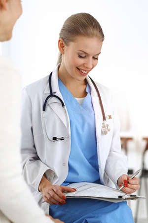 Woman - doctor consults her female patient in sunny clinic