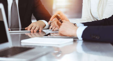 Business people discussing contract while working together in sunny modern office. Unknown...