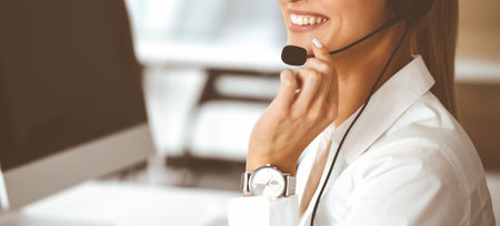 Unknown female customer service representative is consulting clients online using headset.close-up. Call center and business conceptの写真素材