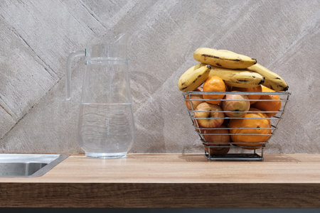 Glass decanter with water and metal fruit basket on the table top. Concept of Still life in the kitchen.の写真素材