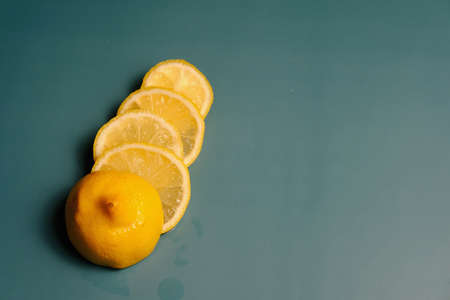 sliced Lemon wedges on the turquoise surface. Source of vitamin C during cold and flu season. Copy space image.の写真素材