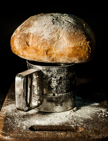 peasant bread on a flour board black backgroundの写真素材