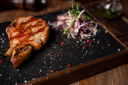 The restaurant is the main meat dish. Steak on the board. Red wine. Peppers and cabbage saladの写真素材