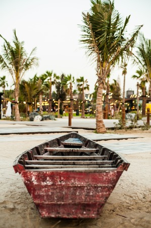 an old wooden boat on the beach under the palm tree