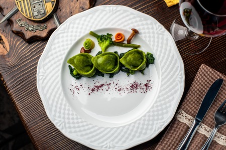 Green Ravioli with quail egg. A Halloween Feast. Black brick wall background and wooden tableの写真素材