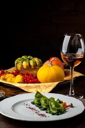 Green Ravioli with quail egg. A Halloween Feast. Black brick wall background and wooden tableの写真素材