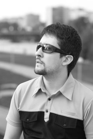 Young man with his mouth open looking up at something in astonishment on city view background in black-and-whiteの写真素材