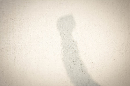 shadow of human hand on abstract wallの写真素材