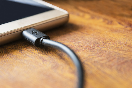 Charger plug phone on wooden table backgroundの写真素材