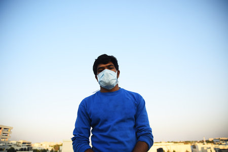 Bengaluru,Karnataka,India -01-04-2020 : Masked man looking out with a hopeのeditorial素材