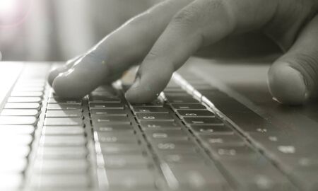 close up of a hand typing on a keyboard