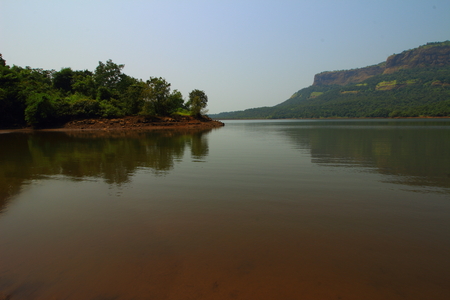 View of the backwaters of Bhira Dam with this hills of the Western ghats, Maharashtra, India in the background.の写真素材