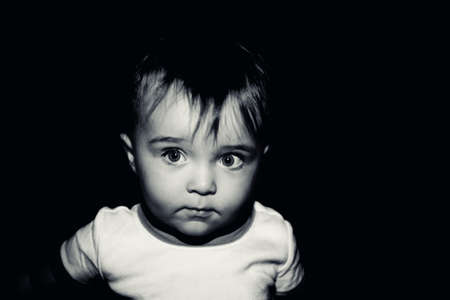 A portrait of a toddler in deep thought processed in lightly toned black and white
の写真素材