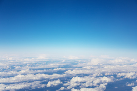 A blue sky cloudscape background with beautiful white clouds shoted from airplane