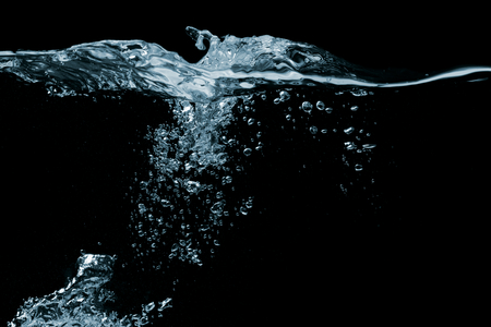 Clear water surface on a black with ripple and bubblesの写真素材