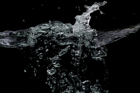 Clear water surface on a black with ripple and bubblesの写真素材