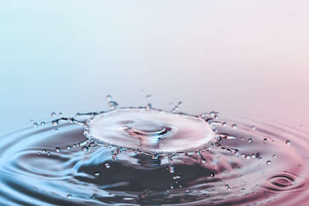 Collision ripple splash of two drops falling into the waterの写真素材