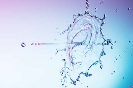 Clear water liquid splash on a blue backgroundの写真素材