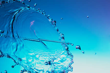 Clear water liquid splash on a blue backgroundの写真素材