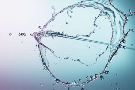 Clear water liquid splash on a blue backgroundの写真素材