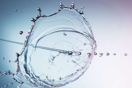Clear water liquid splash on a blue backgroundの写真素材