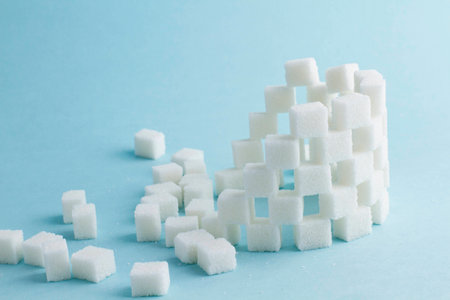 Tower of cubes of sugar and sugar cubes on a blue backgroundの写真素材