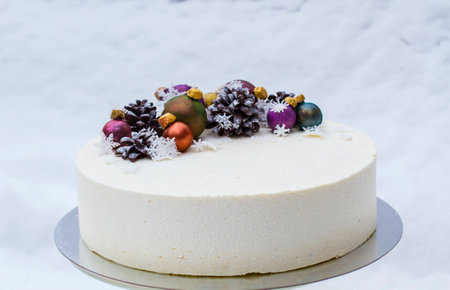 A cake for a Christmas holiday or a new year. A cake with chocolate cones and Christmas-tree toys is...