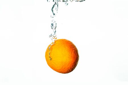 Fresh fruit dives into water with bubblesの写真素材