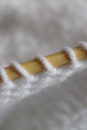 Macro details of soft wool with knitting needle in vertical frame