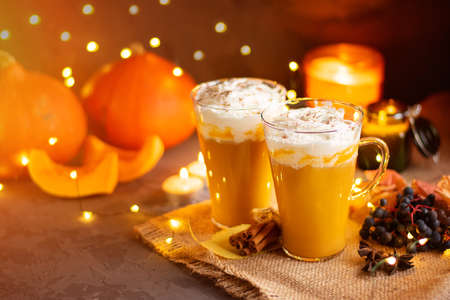 Pumpkin spice latte in a glass mug with cinnamon and whipped cream. Bokeh background. Autumn, winter drinks. Holiday drinks. Christmas drink.の写真素材