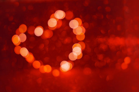 Valentine's Day background, bokeh red heart. Red glitter sparkle confetti. Invitation to the Happy birthday party.の写真素材