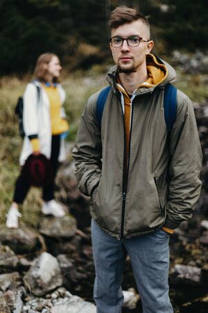 Lovely couple travelling together in the mountains, walking around the lake Morskie oko in Tatry. Relaxed traveller high in the mountains. Appeasement in the nature. Man in glasses and a gray jacket.の写真素材