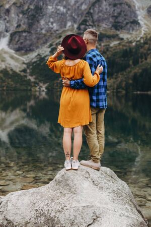 Lovely couple travelling together in the mountains, walking around the lake Morskie oko in Tatry. Amazing girl in yellow dress. Stunning view.の写真素材