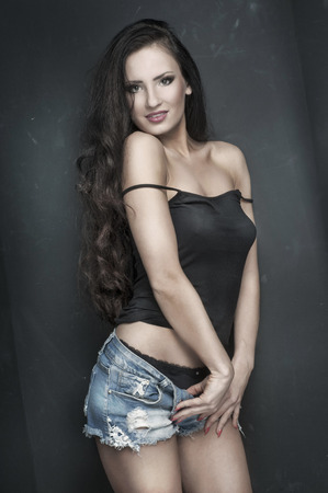Beauty portrait of attractive young brunette woman with long hair. Looking at camera. Woman posing in the studio. Natural makeup. Surprise happy girl.の写真素材