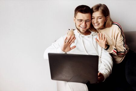 Young couple communicates with family via video communication at home .の写真素材