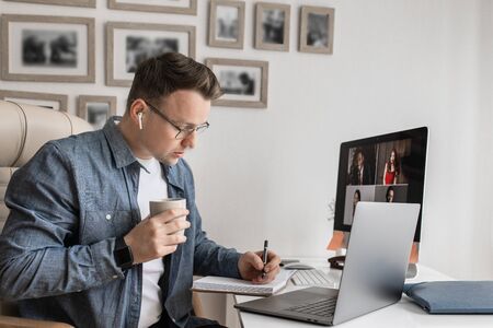 Video chat. Business man working while sitting in front of laptop from home.の写真素材