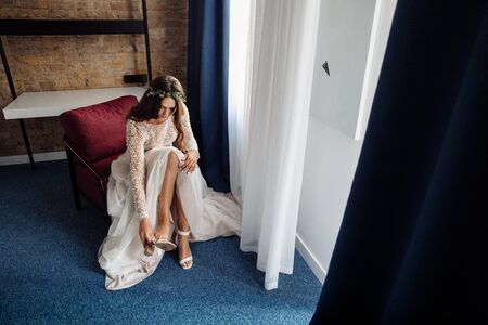 Perfect young bride wearing white shoes at the morningの写真素材