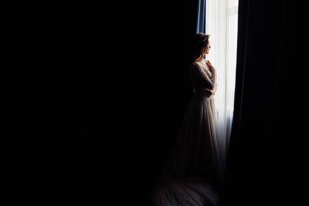 Beautiful bride near the window at the morningの写真素材
