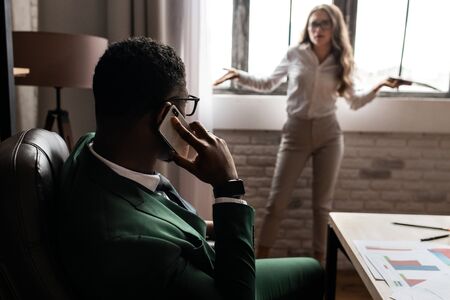Young business woman with phone and handsome african man with laptop at the office . High quality photoの写真素材